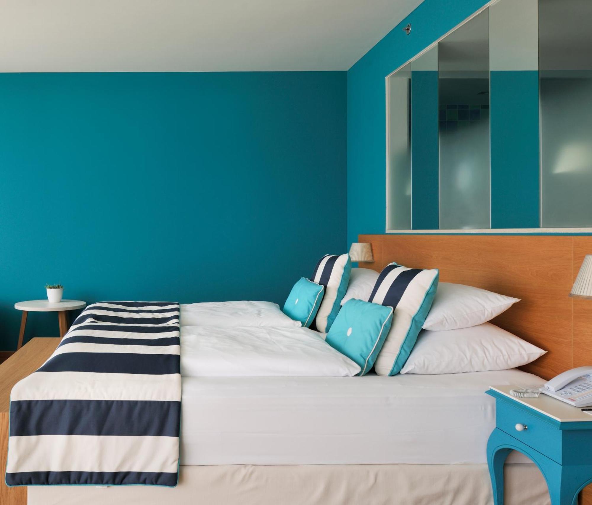 ฟอล์คเคนสไตเนอร์โฮเต็ลแอนด์สปา ลาเดรา Hotel เพทรอซาเน ห้อง รูปภาพ A bedroom with blue walls